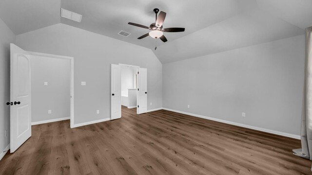 unfurnished bedroom with lofted ceiling, baseboards, wood finished floors, and visible vents