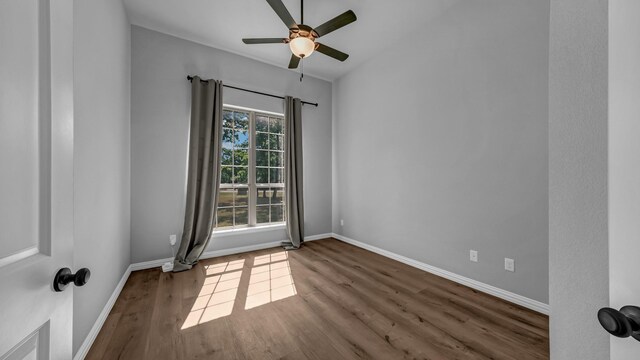 unfurnished room with wood finished floors, baseboards, and ceiling fan