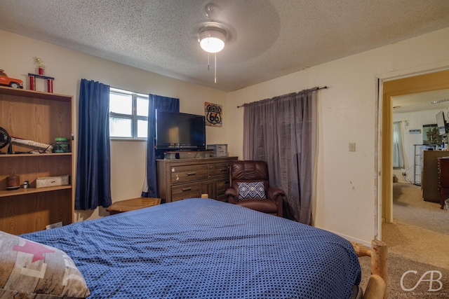 carpeted bedroom featuring a ceiling fan and a textured ceiling