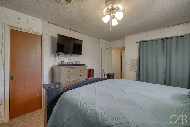 carpeted bedroom featuring a ceiling fan and a textured ceiling