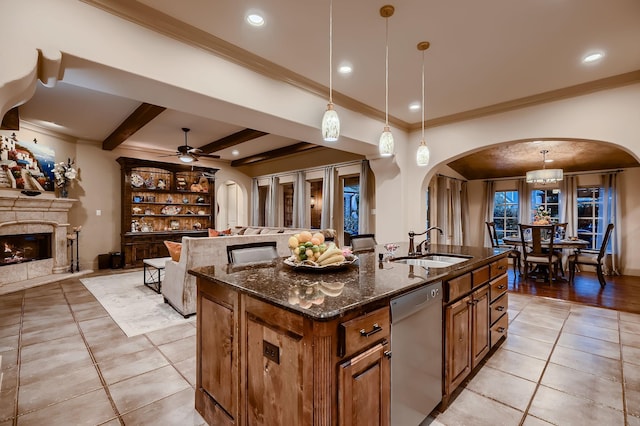 kitchen featuring open floor plan, dishwasher, a sink, and arched walkways