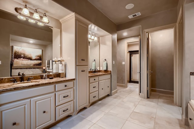 bathroom with two vanities, visible vents, and a sink