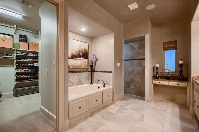bathroom featuring a tile shower, visible vents, a garden tub, and vanity