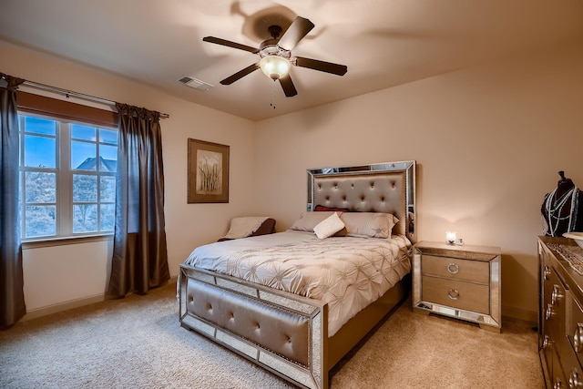 bedroom featuring baseboards, visible vents, and light colored carpet