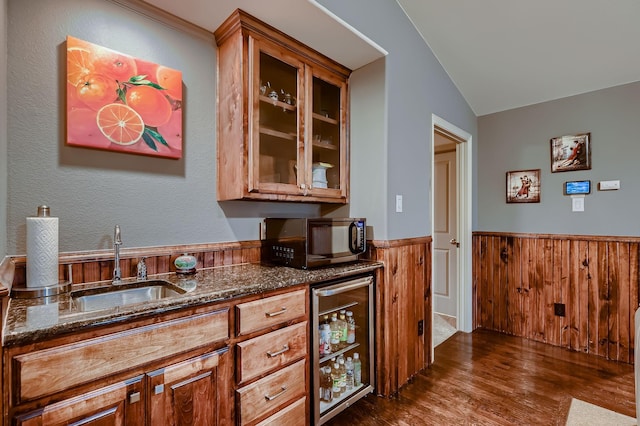 bar featuring wine cooler, a wainscoted wall, vaulted ceiling, black microwave, and dark wood-type flooring