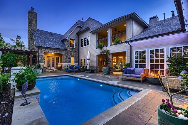pool with an outdoor living space with a fire pit, a patio, ceiling fan, and french doors