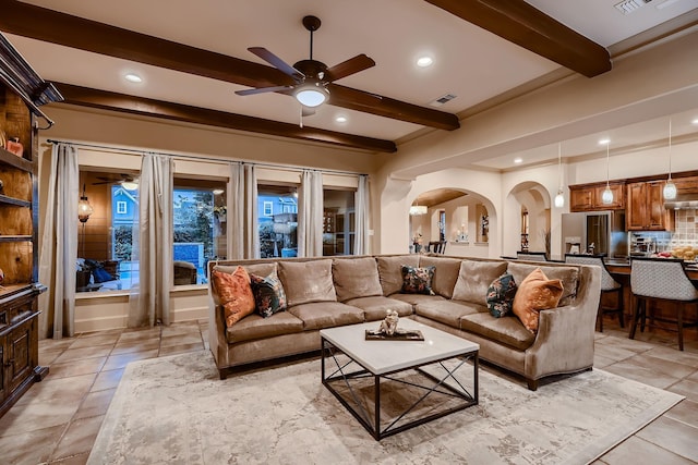 living room with arched walkways, visible vents, beamed ceiling, ceiling fan, and light tile patterned floors