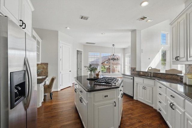 2704 Wisdom Creek Dr, Flower Mound, TX 75022 - kitchen featuring appliances with stainless steel finishes, a sink, a chandelier, tasteful backsplash, and a center island