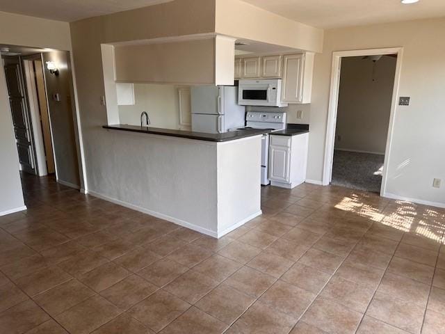 4544 Chaha Rd Unit 103, Garland, TX 75043 - kitchen with white appliances, dark countertops, tile patterned floors, and baseboards