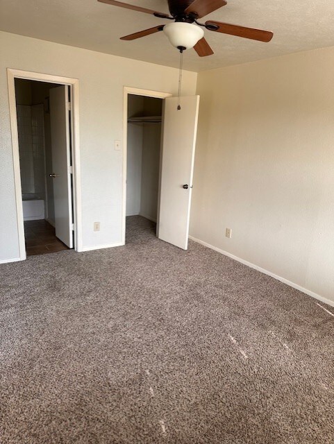 4544 Chaha Rd Unit 103, Garland, TX 75043 - unfurnished bedroom with a closet, carpet floors, baseboards, a ceiling fan, and ensuite bath