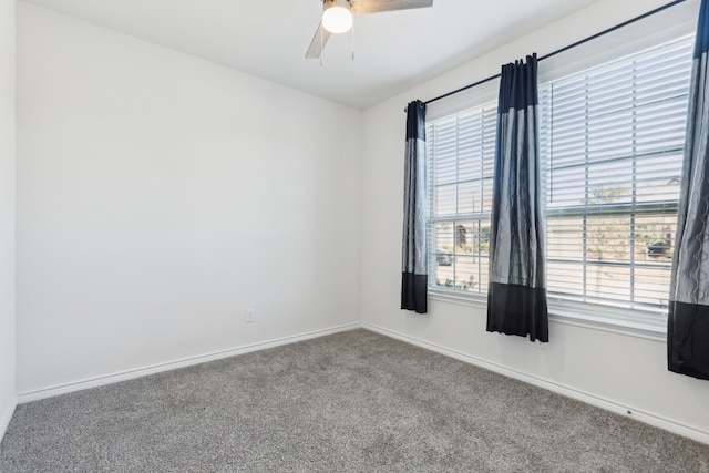 carpeted empty room with baseboards and ceiling fan