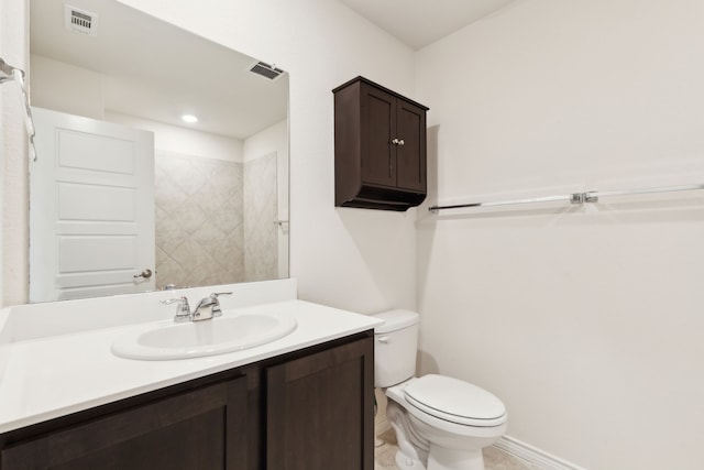 bathroom featuring baseboards, visible vents, toilet, and vanity