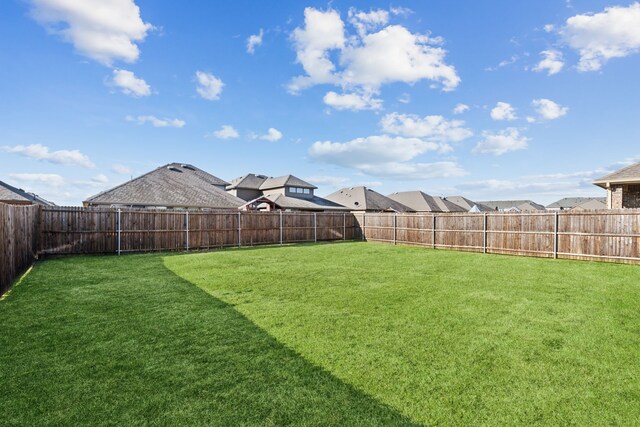 view of yard featuring a fenced backyard and a residential view