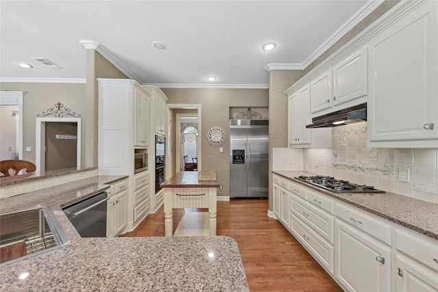 803 Eagle Pass, Heath, TX 75032 - kitchen with built in appliances, under cabinet range hood, ornamental molding, a sink, and wood finished floors
