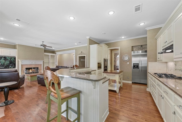 803 Eagle Pass, Heath, TX 75032 - kitchen with appliances with stainless steel finishes, ceiling fan, a kitchen breakfast bar, recessed lighting, and ornamental molding