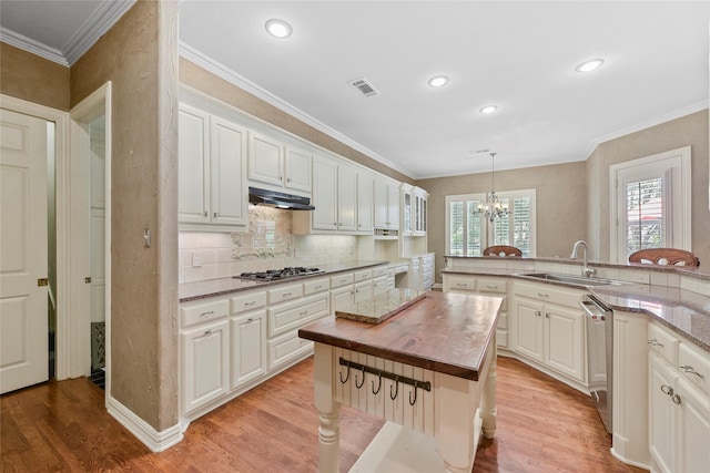 803 Eagle Pass, Heath, TX 75032 - kitchen featuring a sink, butcher block counters, light wood-style flooring, a chandelier, and crown molding