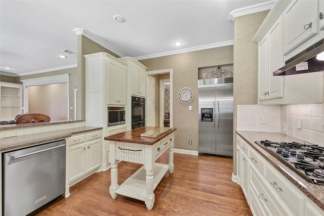 803 Eagle Pass, Heath, TX 75032 - kitchen featuring built in appliances, butcher block countertops, under cabinet range hood, tasteful backsplash, and ornamental molding