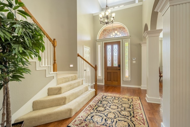 1609 Willow Ln, Mckinney, TX 75072 - entryway with an inviting chandelier, stairway, wood finished floors, and decorative columns