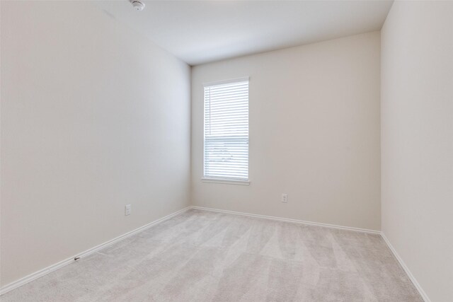 empty room with baseboards and light carpet