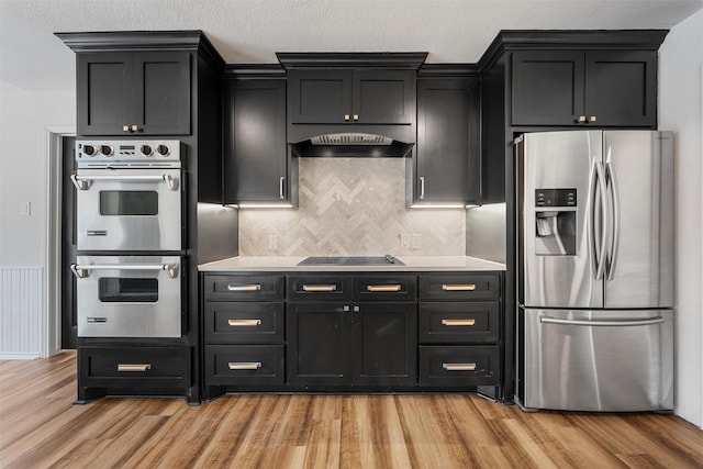 kitchen featuring light countertops, light wood-style floors, appliances with stainless steel finishes, and under cabinet range hood
