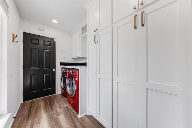 clothes washing area featuring separate washer and dryer, dark wood-style flooring, cabinet space, and recessed lighting