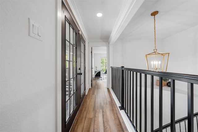 hall featuring french doors, recessed lighting, a notable chandelier, wood finished floors, and ornamental molding