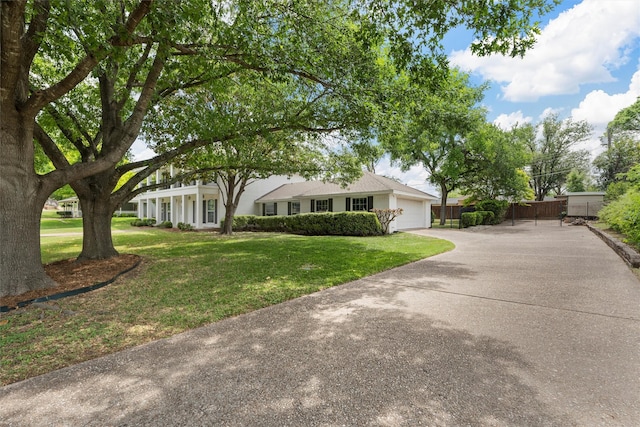 view of front of home with driveway, fence, a front yard, and a garage