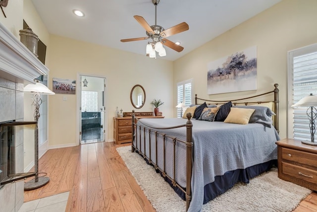 bedroom featuring recessed lighting, light wood finished floors, a ceiling fan, ensuite bath, and baseboards