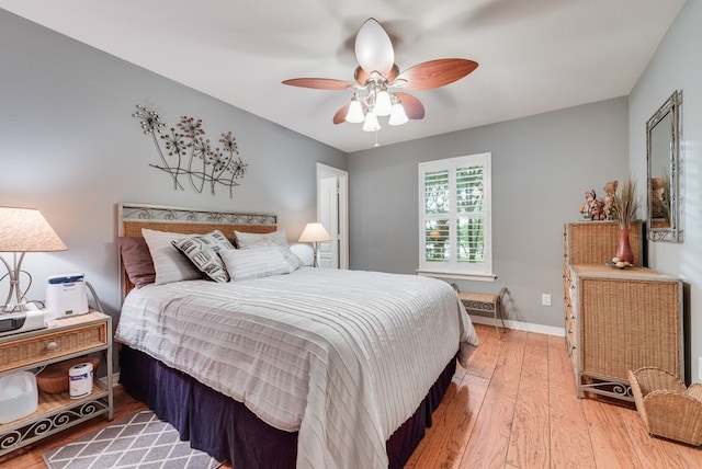 bedroom featuring baseboards, a ceiling fan, and light wood-style floors