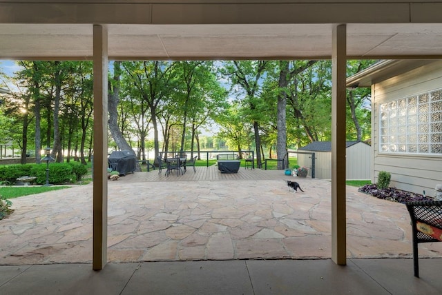 view of patio / terrace featuring an outdoor structure, grilling area, and a shed