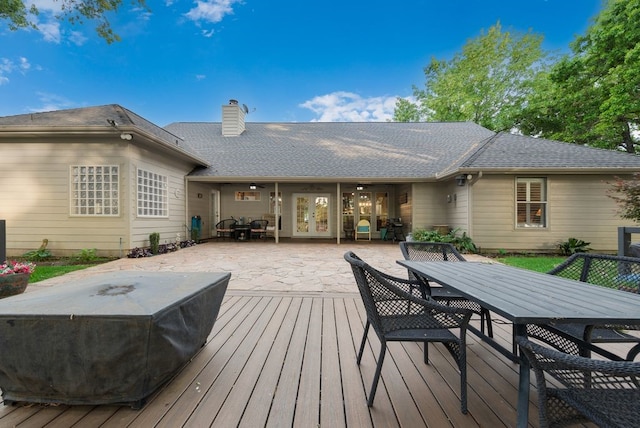 wooden deck with outdoor dining area, a patio area, and french doors