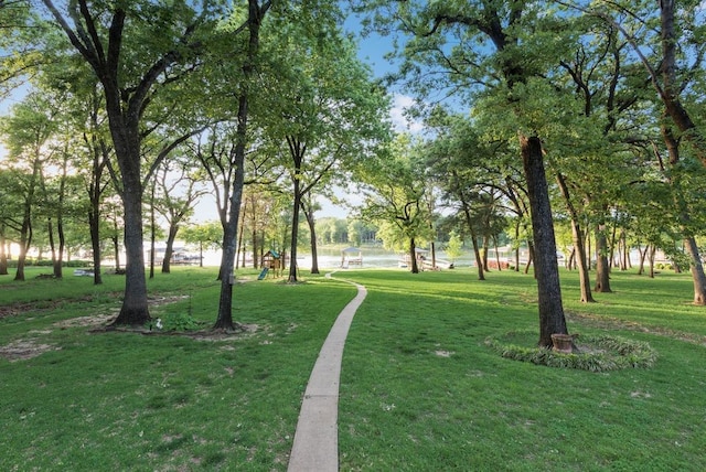 view of property's community with playground community and a yard