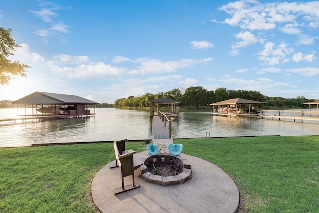 view of yard with a dock, a fire pit, and a water view
