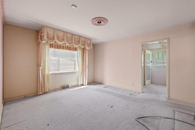 carpeted empty room featuring visible vents and baseboards