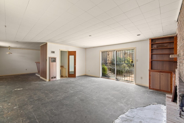 unfurnished living room featuring baseboards and a brick fireplace