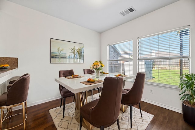 dining area featuring wood finished floors, visible vents, and baseboards