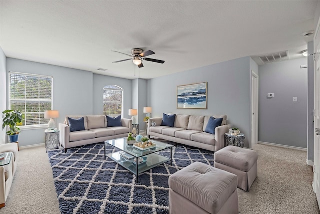 living room featuring baseboards, a ceiling fan, carpet flooring, and visible vents