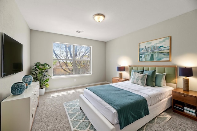 carpeted bedroom with visible vents and baseboards