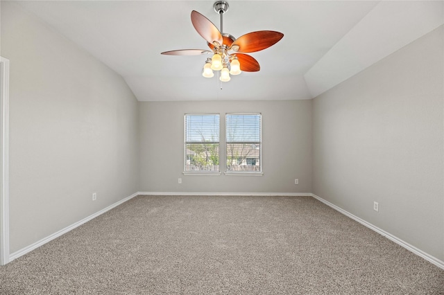 spare room featuring vaulted ceiling, carpet flooring, a ceiling fan, and baseboards