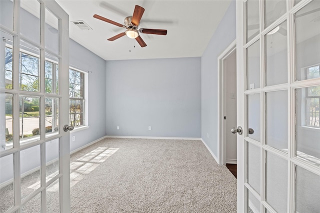 carpeted spare room featuring baseboards, a ceiling fan, french doors, and visible vents