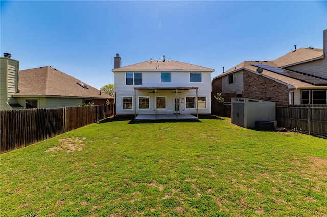 rear view of house with a patio area, a fenced backyard, a storage unit, and ceiling fan