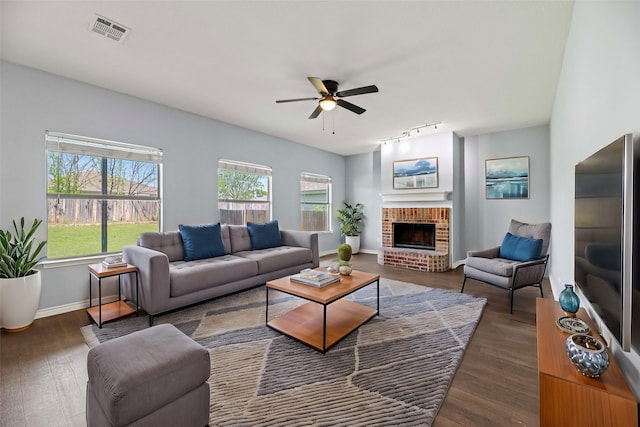living room featuring wood finished floors, visible vents, a wealth of natural light, and ceiling fan