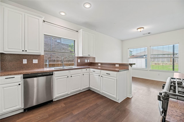 kitchen featuring black range with gas stovetop, a sink, dishwasher, backsplash, and visible vents