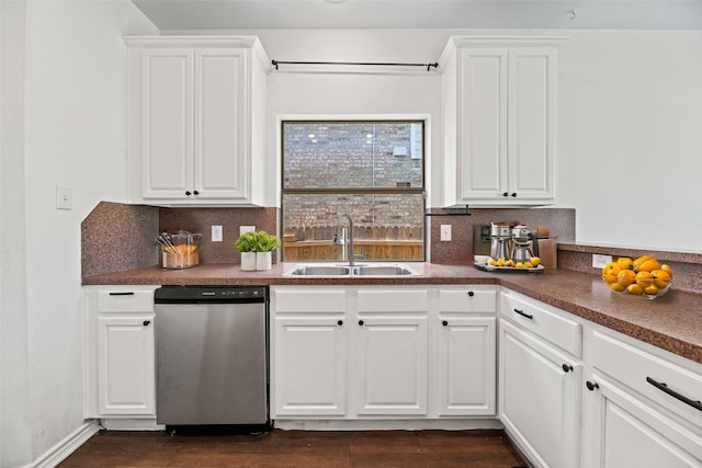 kitchen featuring decorative backsplash, dishwasher, a sink, and dark countertops