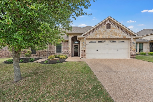 view of front of property with driveway, stone siding, brick siding, a front yard, and a garage