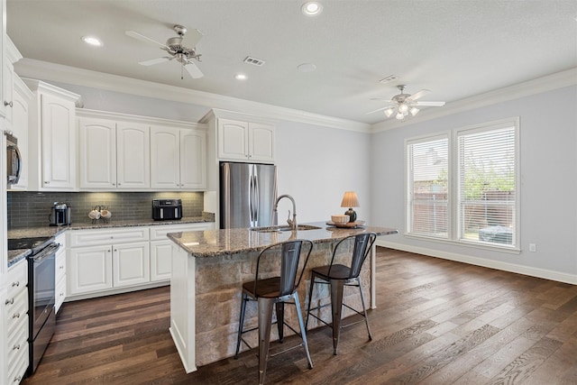 kitchen with electric range, ceiling fan, a sink, and freestanding refrigerator