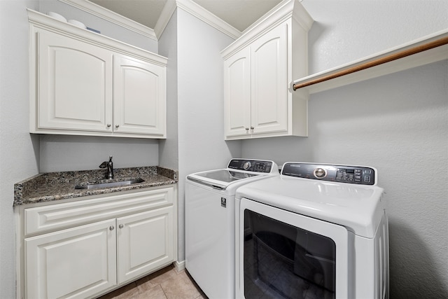 laundry area with cabinet space, washer and clothes dryer, crown molding, and a sink