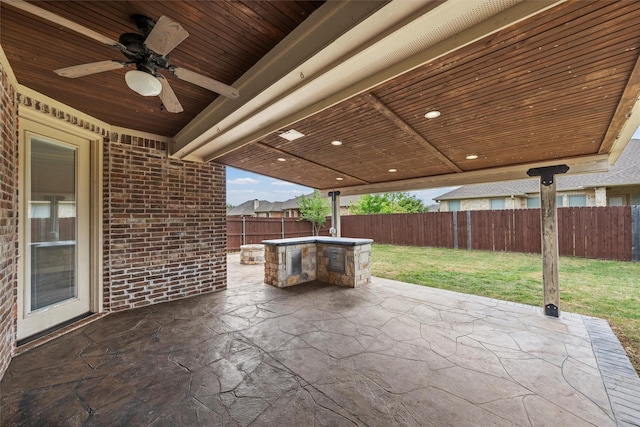 view of patio featuring an outdoor kitchen, a fenced backyard, and a ceiling fan