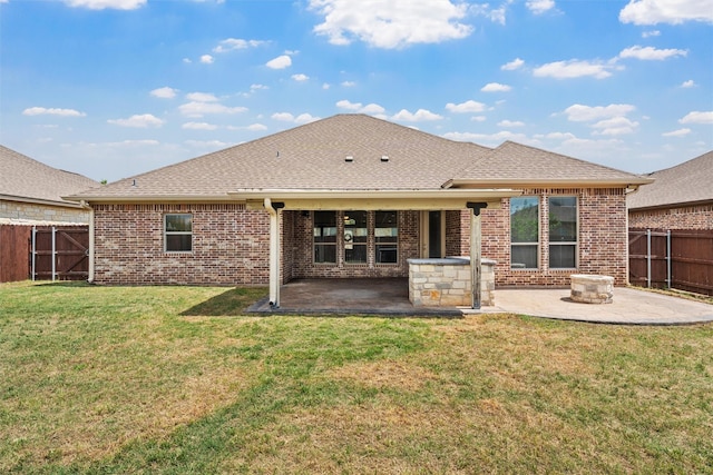 rear view of house with brick siding, a lawn, a fenced backyard, and a patio