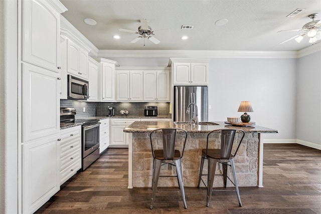 kitchen featuring crown molding, appliances with stainless steel finishes, a ceiling fan, and a sink